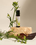 Frangipani Kaffir Lime & Sweet Basil roll-on standing on a sandstone rock