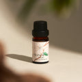 Frangipani Hinoki essential oil bottle in dappled natural light