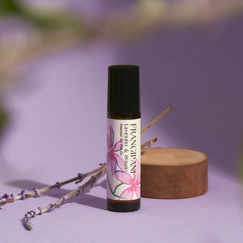 Frangipani Lavender & Hinoki roll-on with dried lavender on lilac