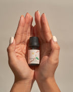 Frangipani Eucalyptus essential oil bottle cradled in cupped hands