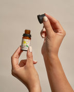 Hands opening a bottle of Frangipani Peppermint essential oil